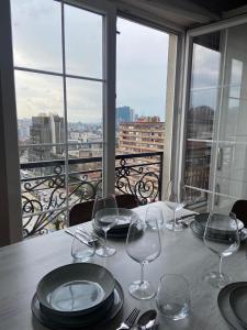 a table with plates and wine glasses on a balcony at Downtown Apartments in Prishtinë