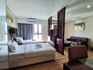 Habitación de hotel con 2 camas y sofá en Ming Greenage Suite 明绿时代套房 @Kota Kinabalu 亚庇市中心 en Kota Kinabalu