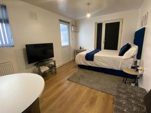 A television and/or entertainment centre at Private Studio Outhouse near Heathrow- Free Parking