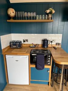 a kitchen with a counter with a stove top oven at Redfox Shepherds hut and private hot tub in Ballynameen