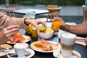un grupo de personas sentadas en una mesa desayunando en Hotel Bed4U Santander, en Santander