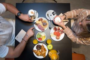un grupo de personas sentadas en una mesa con comida en Hotel Bed4U Santander, en Santander