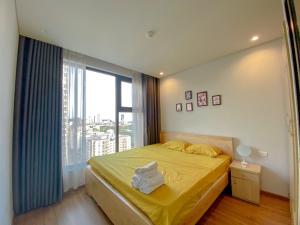 a bedroom with a bed with yellow sheets and a window at Rio Ha Long Homestay - Green Bay Garden in Ha Long +23 photos
