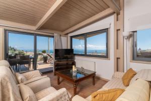 una sala de estar con un sofá y una mesa en Orizontas Loft with Panoramic View, en Zakynthos