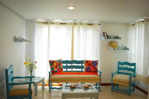 a living room with two chairs and a table at Villas de Alcala in Oaxaca City