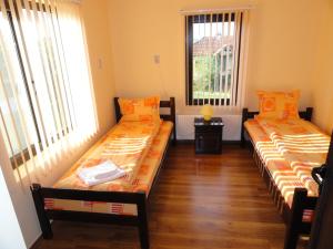 two beds in a room with two windows at Guest House Relax in Dŭbravka