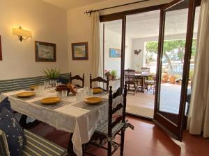 タマリウにあるLa mejor terraza de Tamariuのダイニングルーム(白いテーブルクロスと椅子付)