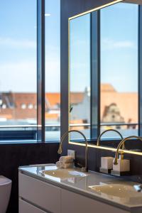 a bathroom with two sinks and a large window at Luxus Penthouse über den Dächern von Nürnberg in Nuremberg