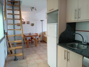 a kitchen with a sink and a ladder next to a table at Casa Adrián in Sabardes