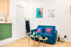 a living room with a blue couch and a table at Andy Home - Cosy studio near the Eiffel Tour in Paris
