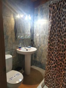 a bathroom with a sink and a toilet and a shower curtain at Posada La Maza in Arnuero +26 photos