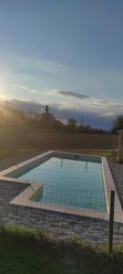 una gran piscina en medio de un campo en Le Petit Riousset, gîte à la campagne, piscine, petit-dèj en Montvendre