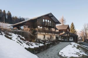 a large wooden house with snow on the ground at L'ivresse du Mont-Blanc in Saint-Gervais-les-Bains