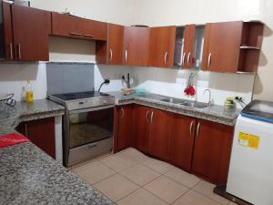 a kitchen with wooden cabinets and stainless steel appliances at D La Costa Hotel4 in Machala