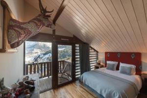Dormitorio con cama con cabeza de ciervo en la pared en L'ivresse du Mont-Blanc, en Saint-Gervais-les-Bains