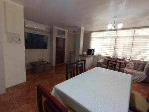 a living room with a white table and a couch at D La Costa Hotel4 in Machala