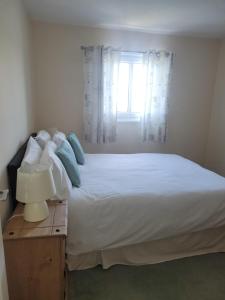 a bedroom with a large white bed with a window at Portmadog, Oakley Wharf in Porthmadog