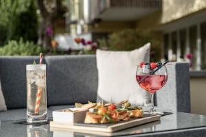 a table with a glass of wine and a plate of food at Hotel Mignon Meran Park & Spa in Merano
