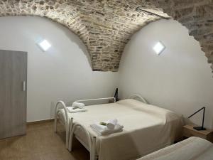 a bedroom with two beds and a brick wall at La Tavernetta in Pietra Montecorvino