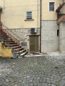 un edificio con una puerta y escaleras junto a un edificio en La Tavernetta, en Pietra Montecorvino