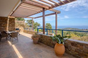 eine Außenterrasse mit einem Tisch und einem großen Fenster in der Unterkunft Maison Piscine Vue mer in Bormes-les-Mimosas