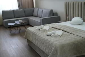 a living room with a bed and a couch at Cross Resort Hotel in Yerevan