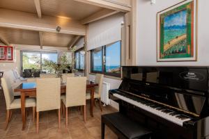 a dining room with a piano and a table with chairs at Orizontas Loft with Panoramic View in Zakynthos