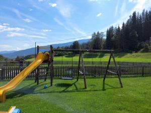 einen Spielplatz mit Rutsche im Gras in der Unterkunft Pension Edlinger in Sankt Georgen ob Murau