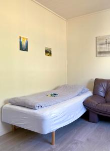łóżko w pokoju obok krzesła w obiekcie Liv's Guesthouse w mieście Torshavn