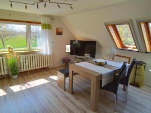 a dining room with a table and a television at Haus im Wind in Putbus