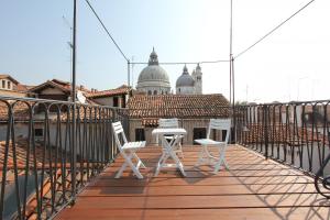 2 sillas blancas y una mesa en el balcón en City Apartments Salute-Accademia, en Venecia