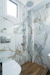 a bathroom with a shower with marble tiles at Angela Rooms in Leptokaria