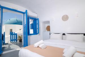 a bedroom with a bed and a blue door at Luxus VIP Suites in Oia