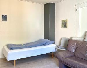 uma cama num quarto com um sofá em Liv's Guesthouse em Tórshavn