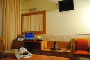 une chambre d'hôtel avec un ordinateur portable sur un bureau dans l'établissement Hotel Ideal, au Pirée
