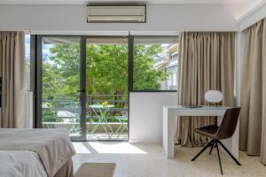 a bedroom with a bed and a desk and a window at Aura Homes, Contemporary Apartments in Central Athens in Athens