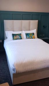 ein großes weißes Bett mit zwei Kissen darauf in der Unterkunft Pv Fallons in Longford