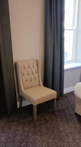 una silla sentada en una habitación con ventana en Pv Fallons, en Longford