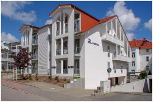 a large white building with a red roof at Neubau-Villa-Strandidyll-Typ-4-Apartment-E4 in Binz