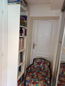 a room with a door and a chair in a book shelf at Chez Aurore et Adri in Ollioules