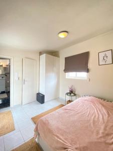 1 dormitorio con cama rosa y cocina en Private Apt. Acropolis View. Top Floor. Koukaki, en Atenas