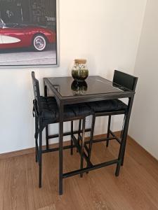 un tavolo nero e una sedia con un vaso sopra di Chez Aurore et Adri a Ollioules