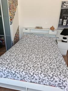 a white bed with a black and white pattern on it at Chez Aurore et Adri in Ollioules