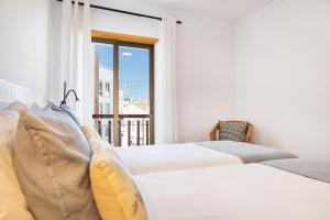 1 dormitorio con 2 camas y ventana en Downtown Poet´s Apartment, en Faro