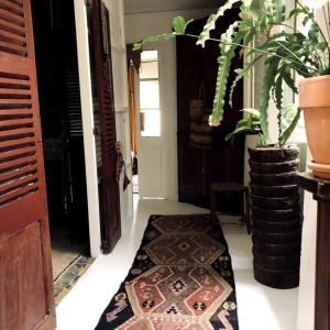 a hallway with a rug on the floor next to a door at Atypical Town House in Uzès. in Uzès