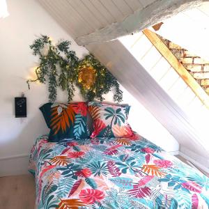 ein Schlafzimmer mit einem Bett mit bunten Kissen in der Unterkunft EssenCiel du lac III in Éguzon-Chantôme