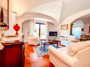 a living room with white furniture and a tv at Casa Sterlizia [Olbia] in Olbia