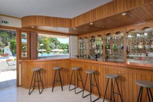 a bar with stools in a room with wooden walls at Eleonas Apartments in Ialysos