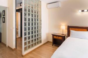 a bedroom with a bed and a wall of pictures at Siena Urban Live Canarias in Santa Cruz de Tenerife