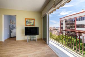 a living room with a large balcony with a flat screen tv at Siena Urban Live Canarias in Santa Cruz de Tenerife